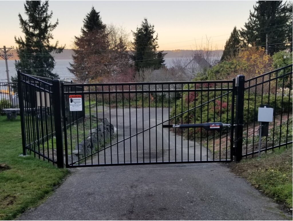 Black automatic driveway gate with keypad entry installed by Goodrow's Fence & Deck